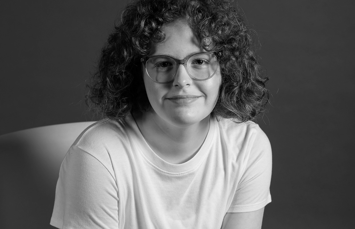 Black and white image of teenager wearing glasses and a white t-shirt