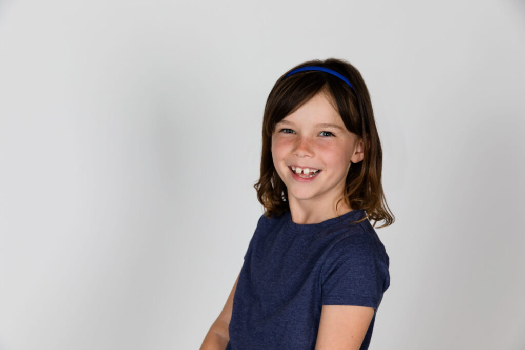 Brown haired Girl in Blue Tshirt smiling