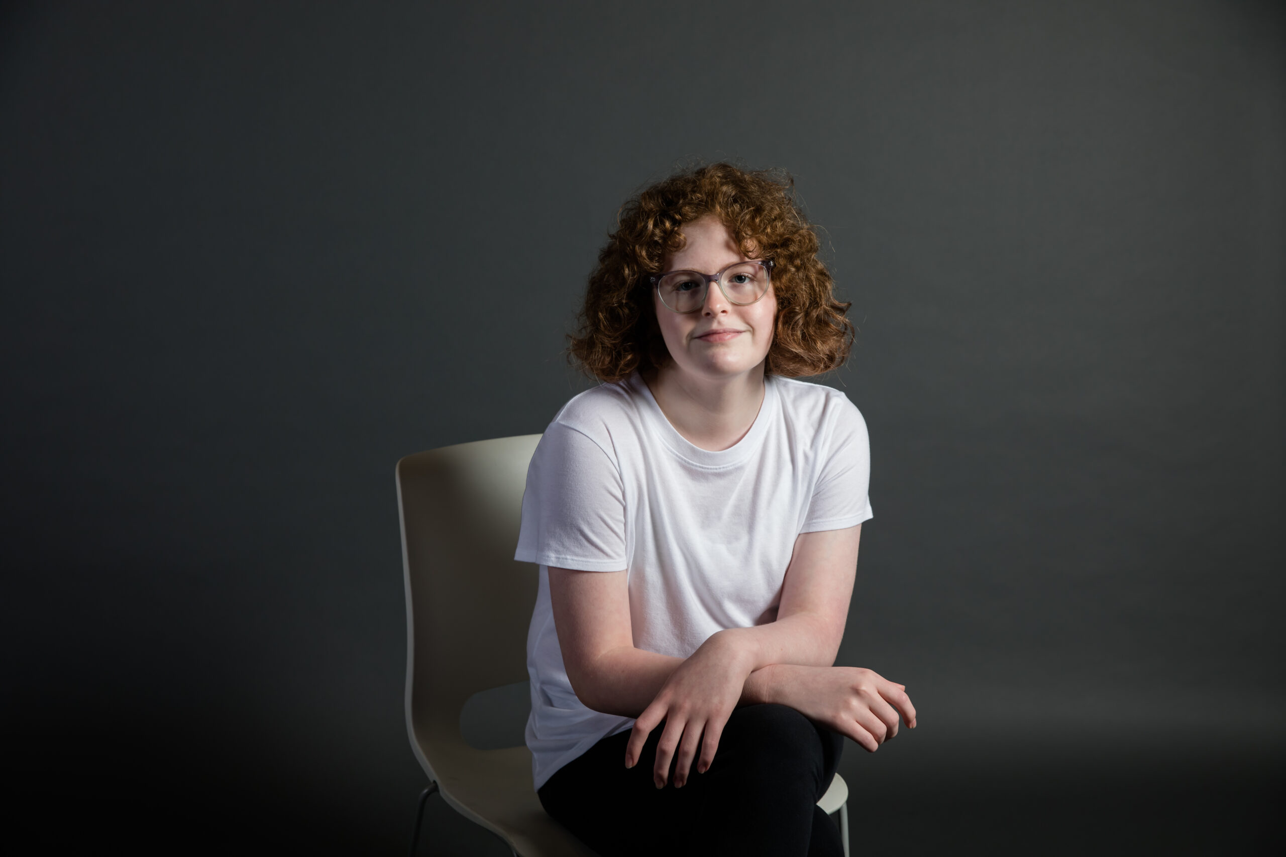 Girl with Red curly hair sitting on chair