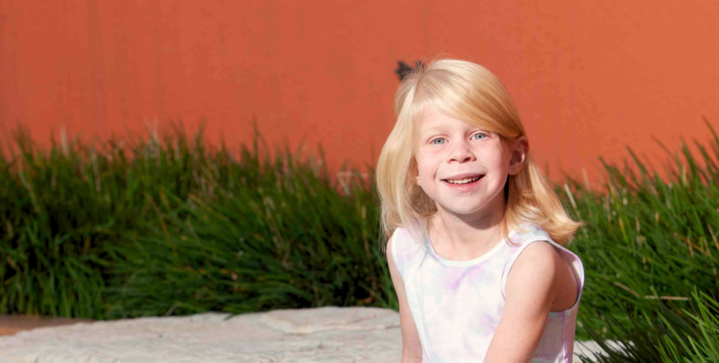 young girl with blond hair and pink dress