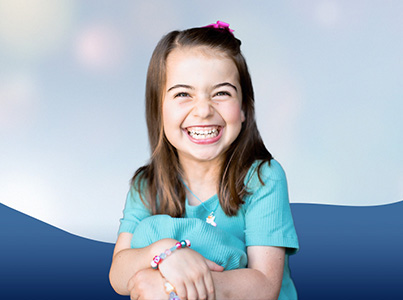 smiling girl wearing light blue shirt with blue background