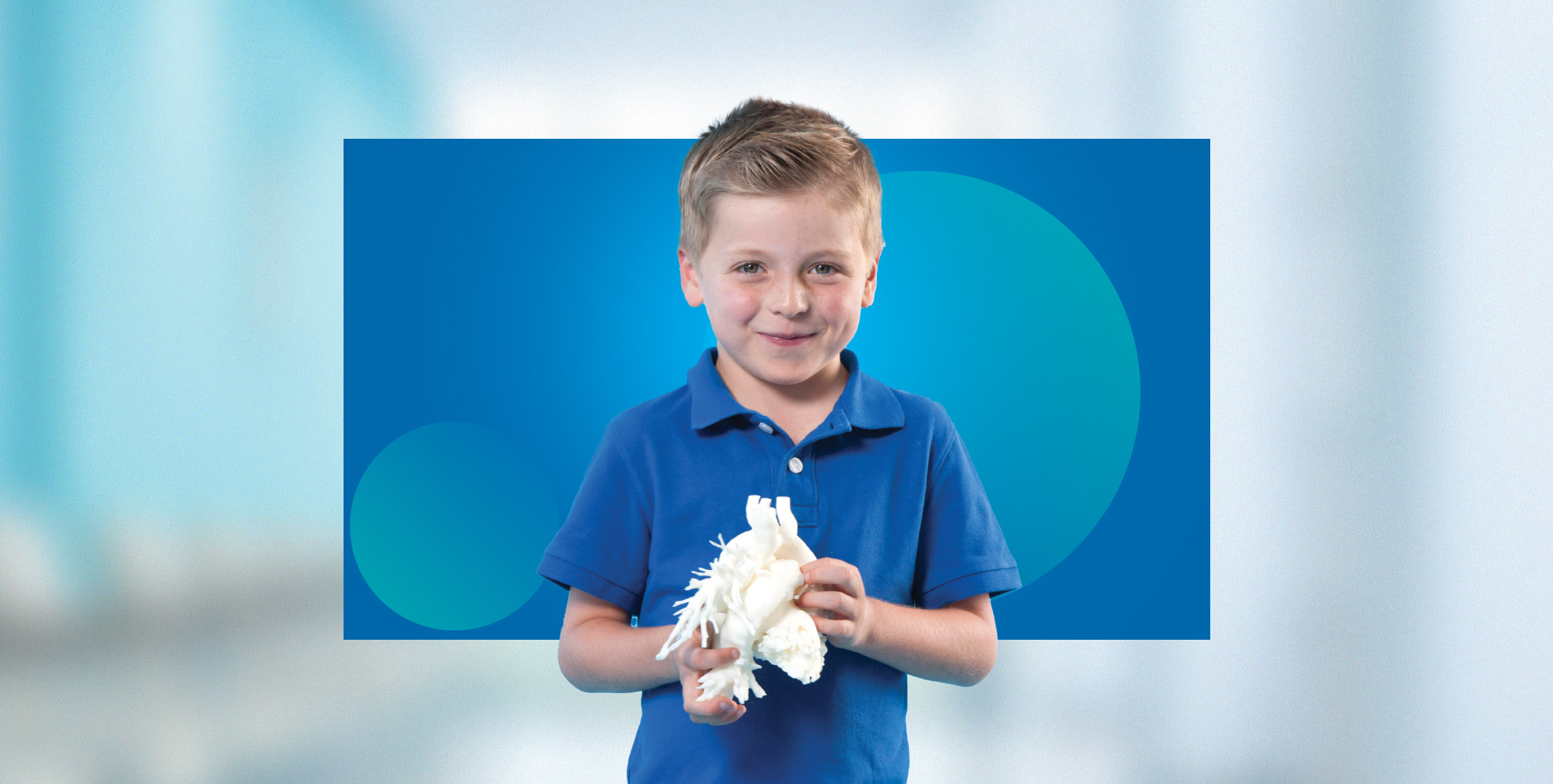 young boy holding 3D printed heart