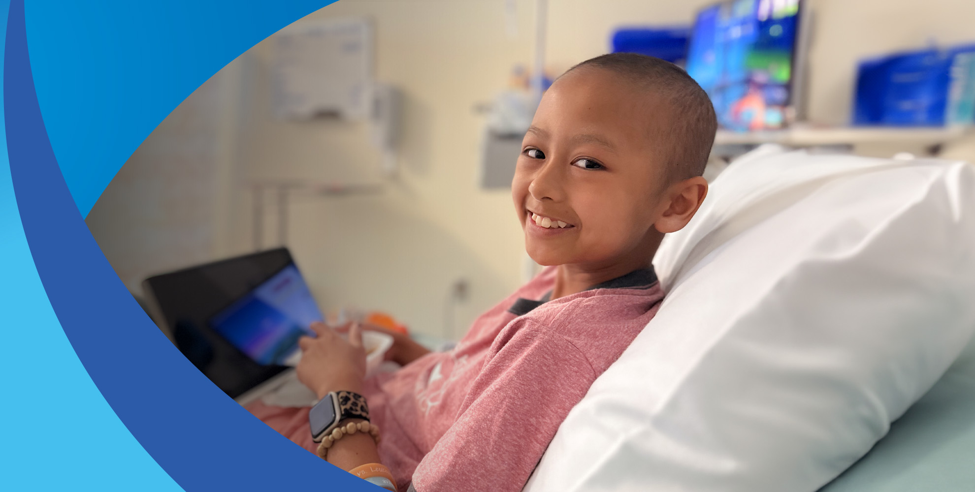 Young girl in hospital bed smiling at camera