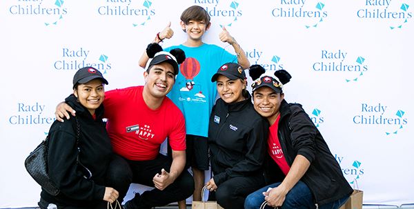 Four Panda employees with Rady Children's patient, Landon