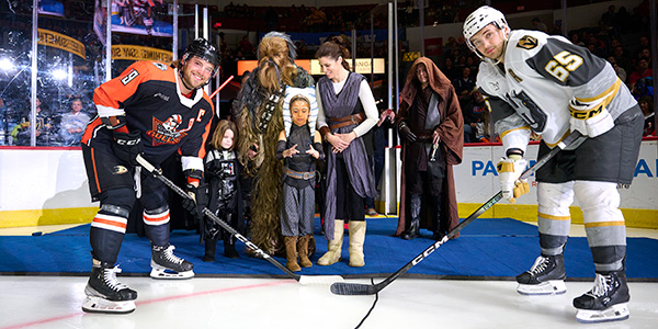 hockey players on ice with guests dressed in star wars attire