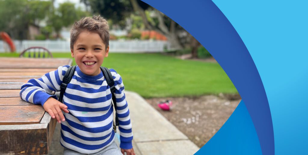 A boy in a striped sweater and a backpack