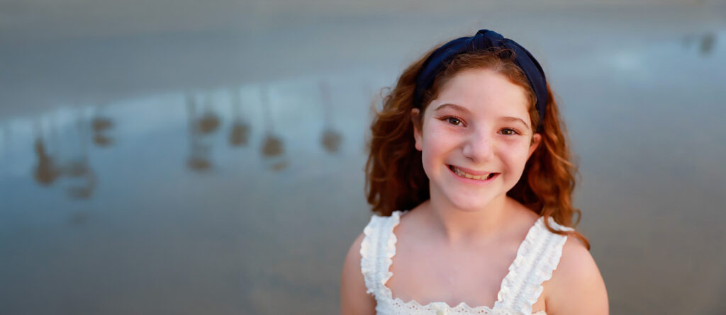 Girl wearing white dress smiling at camera