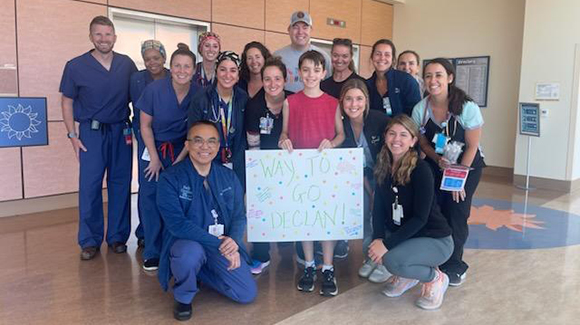 boy standing with group of hospital staff in hallway