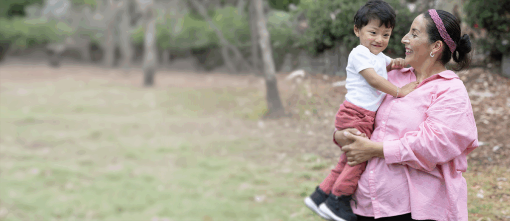Mom holding toddler son and smiling