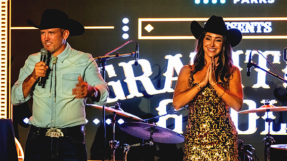 Man and women speaking on stage at country music concert