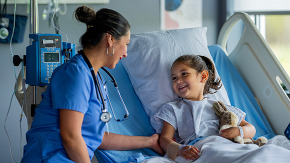 Healthcare provider with young girl in hospital bed