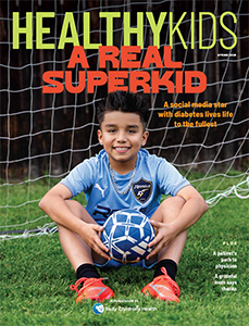 Healthy Kids, A Real Superkids, cover image of boy wearing light blue shirt holding soccer ball sitting on grass in front of goal